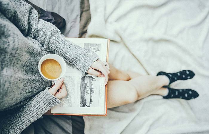 Woman having coffee and reading a book