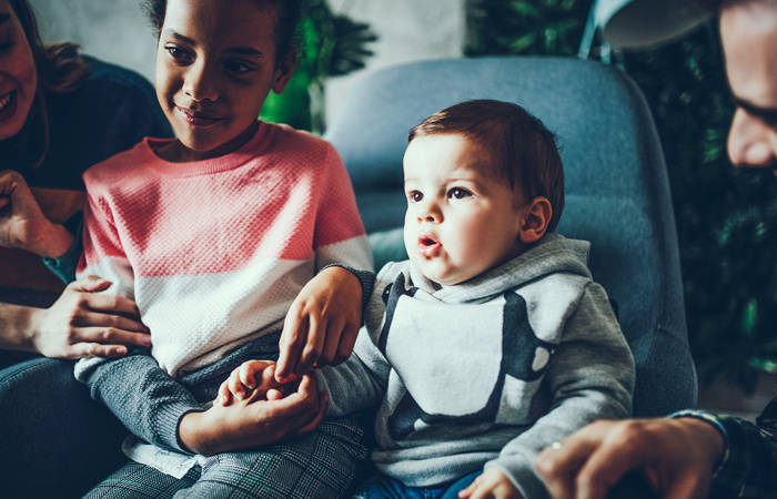 Foster parents watching TV with their children