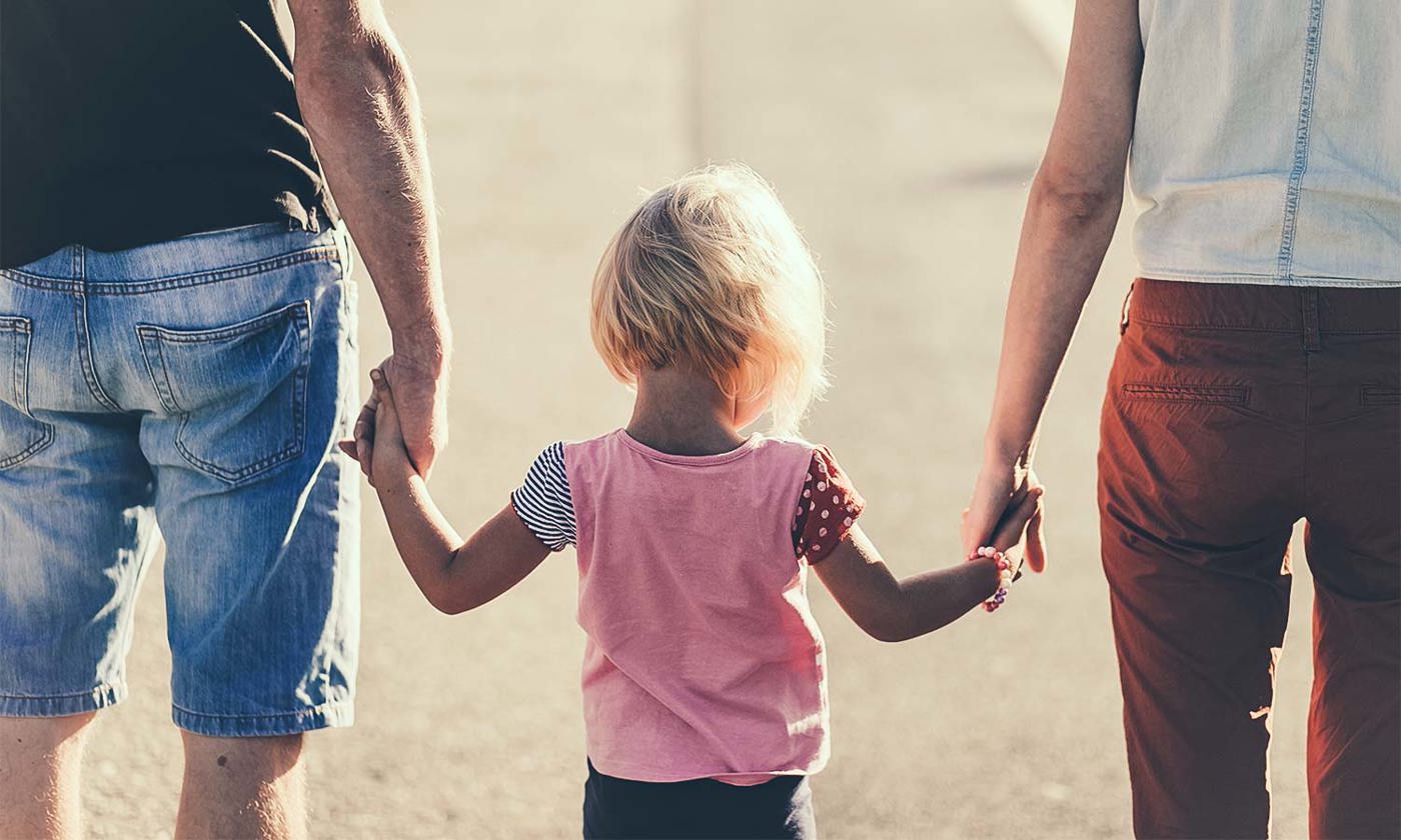 Mother, father and child walking holding hands