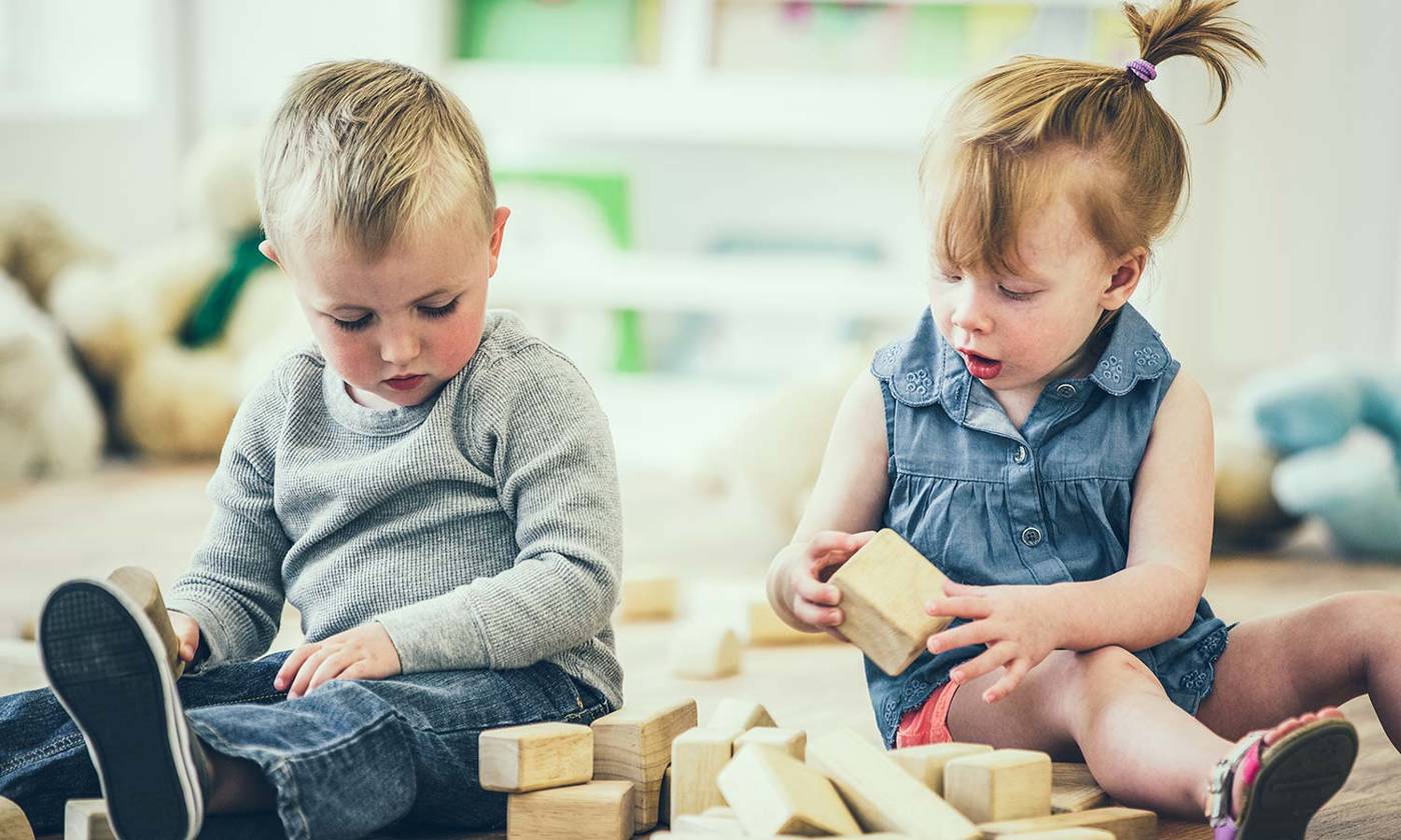 Boy and girl sharing blocks