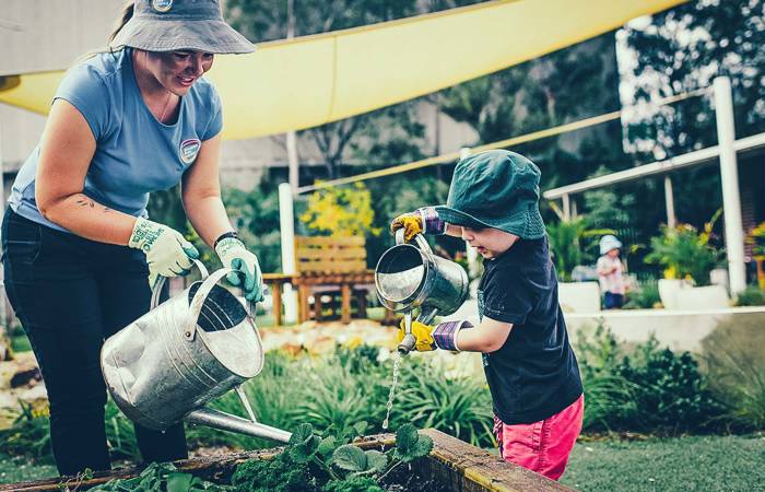 Preschool teacher in garden with child