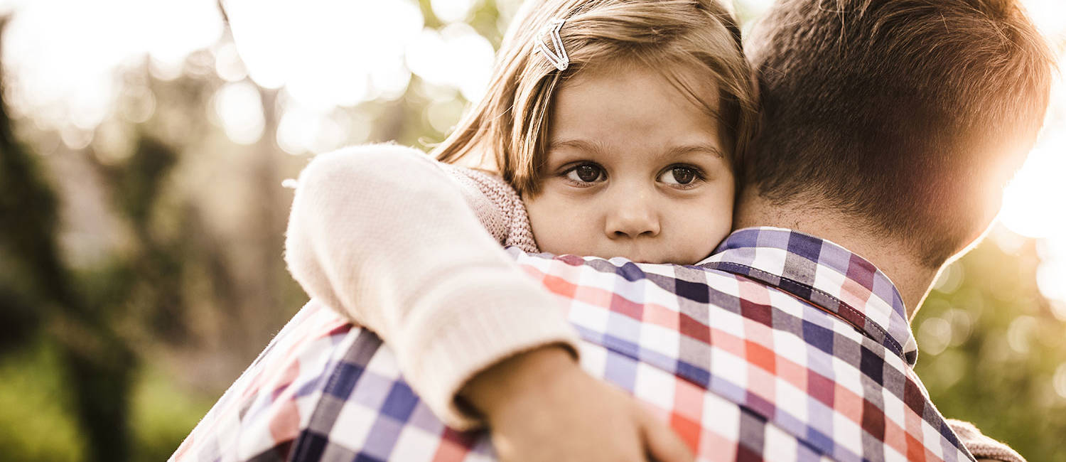 Young girl being consoled by her father