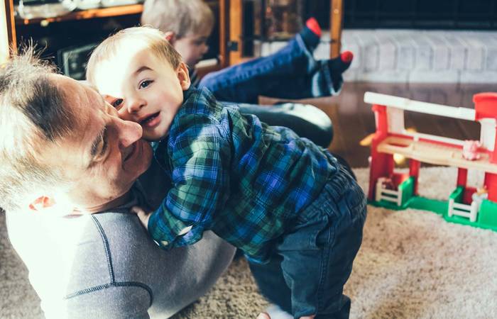 Elderly man playing with small children