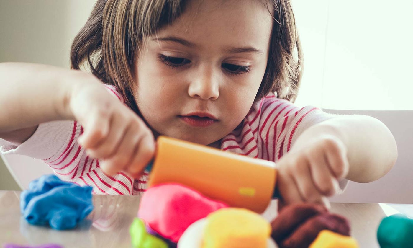 Girl rolling play dough